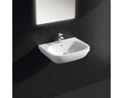 Keramikwaschtisch mit Armatur und Spiegel vor einer dunklen Wand