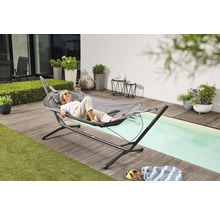 Frau entspannt sich in Hängematte mit Gestell auf Terrasse