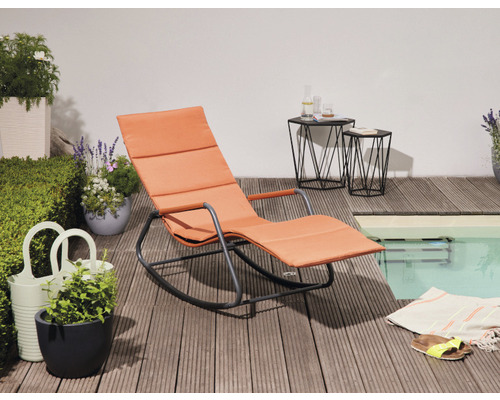 Szene mit Gartenliege, Beistelltischen und Dekoration auf einer Holzterrasse