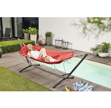 Szene im Freien mit Frau, die in einer roten Hängematte auf einer Terrasse entspannt