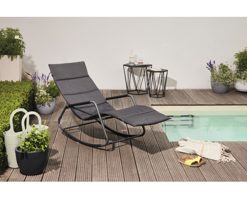 Garten Szene mit einer grauen Liege, zwei Beistelltischen und Pflanzen neben einem Pool auf einer Holzterrasse.