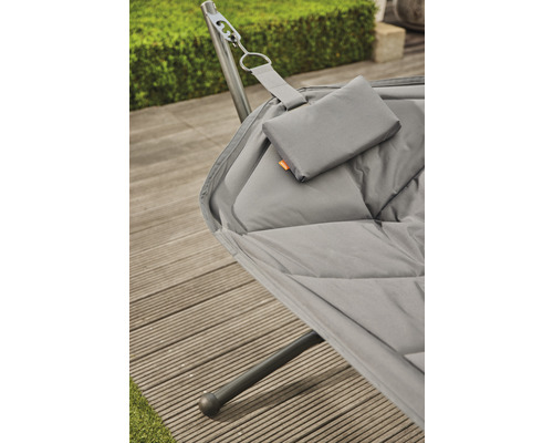 Detailansicht einer grauen Hängematte mit Kissen und Gestell auf einer Holzterrasse