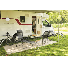 Campingplatzszene mit Wohnwagen, Tisch, Stühlen, Liegestuhl und Fahrrad