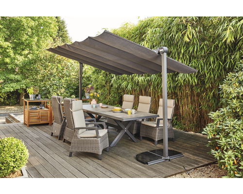 Gartenszene mit Esstisch, Stühlen und Sonnenschirm auf einer Terrasse.