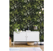 Dekoratives Interieur mit Pflanzenmuster-Tapete, weißem Schrank und Stehlampe