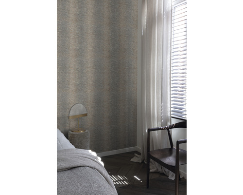 Schlafzimmer mit gemusterter Tapete, Bett, Lampe und Stuhl