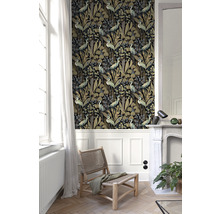 Wohnraum mit gemusterter Tapete mit Pflanzen- und Vogelmotiven, Stuhl und Kamin