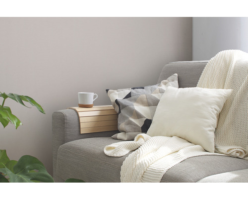 Gemütliche Wohnzene mit Sofa, Kissen, Decke und Beistelltisch