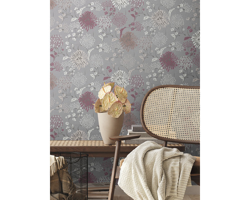 Dekoratives Interieur mit floral gemusterter Tapete, Holzelementen und Textilien