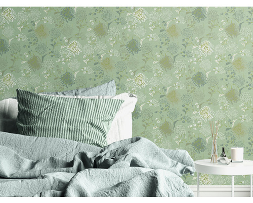 Schlafzimmer mit floraler Tapete, Bett und Beistelltisch.
