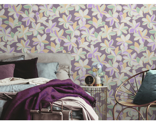 Schlafzimmer mit floral gemusterter Tapete, Bett, Stuhl und Beistelltisch.