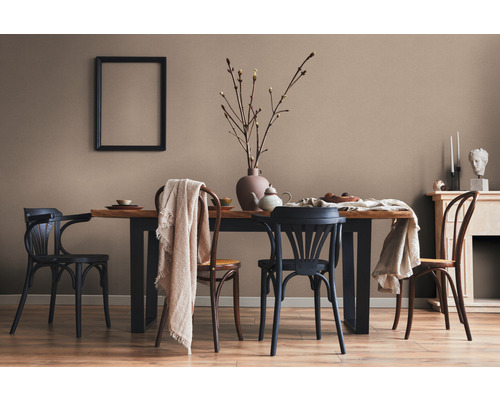 Esszimmer mit Holztisch, Stühlen, Dekoration und einem Bilderrahmen an der Wand.