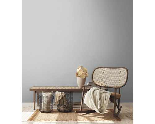 Wohnzimmer mit Holzbank, Rattanschaukelstuhl und Dekorationen