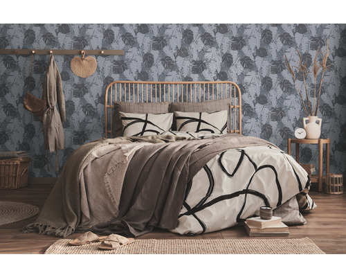 Ein Schlafzimmer mit einem Bett, einer Wand mit Blättermuster und dekorativen Elementen.