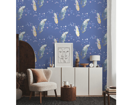 Ein Wohnzimmer mit floral gemusterter Tapete, einem Sessel und einem weißen Schrank.