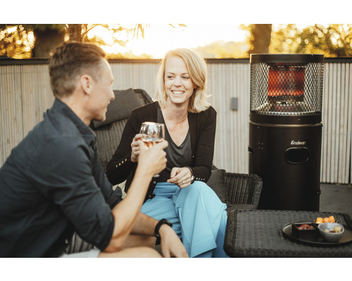 Ein Paar stößt mit Wein neben einer Heizpyramide an