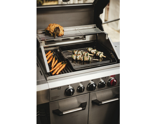 Edelstahl Grill mit zubereiteten Karotten, Gemüsespießen und Braten