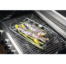 Fisch im Grillkorb auf einem Gasgrill mit Zitrone, Zwiebeln und Lauchzwiebeln