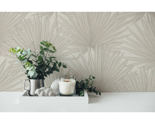 Nahaufnahme von gemusterter Tapete mit Pflanzen und Kerze auf einem Tisch.