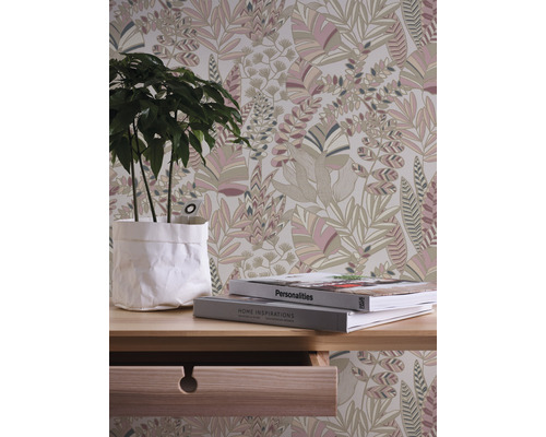 Dekoratives Zimmer mit Blumentapete, Pflanze und Büchern auf einem Tisch.