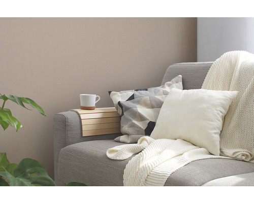 Gemütliche Wohnzene mit Sofa, Kissen, Decke und Beistelltisch