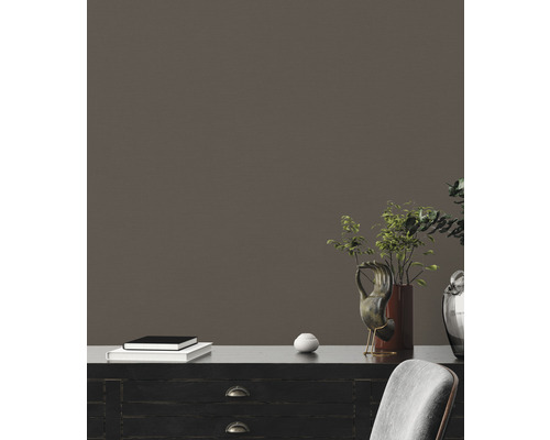 Dekorative Inneneinrichtung mit einem schwarzen Schrank, Pflanzen, Kunstobjekten und einem Stapel Bücher