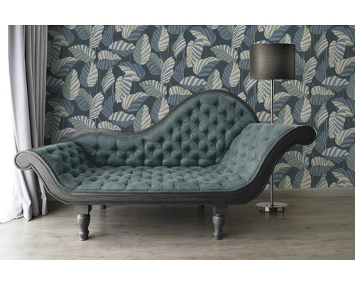 Szene mit einer Chaiselongue, einer Stehlampe und einer floralen Tapete.