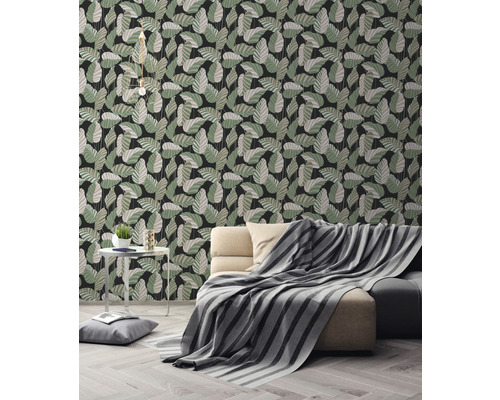 Wohnzimmer mit Couch und Wandtapete mit Blattmuster.