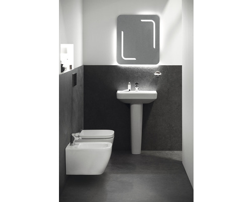 Badezimmer mit Waschtisch, Spiegel und Bidet.