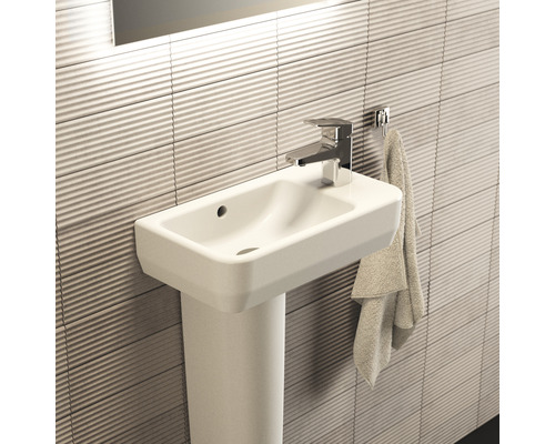 Waschtisch mit Waschtischsäule, Armatur und Handtuch im Badezimmer