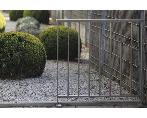 Metallzaun im Garten mit Kiesboden und Büschen