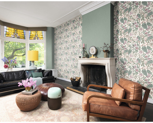 Wohnzimmer mit Sofa, Sessel, Couchtischen, Teppich, Kamin und Tapete mit Pflanzenmuster