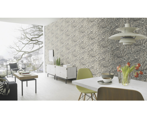 Wohnzimmer mit floral gemusterter Tapete, Esstisch, Stühlen und Sideboard