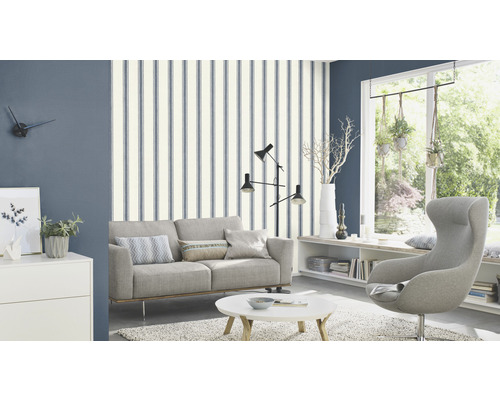 Wohnzimmer mit Sofa, Sessel und gestreifter Tapete für eine stilvolle Raumgestaltung