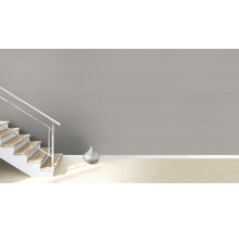 Heller Raum mit Treppe, silberner Vase und Parkettboden.