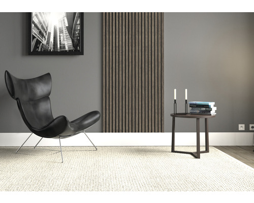 Wohnzimmer mit Sessel, Wandpaneel, Beistelltisch, Büchern, Kerzen und Teppich