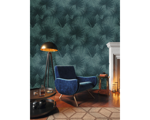 Dekoratives Wohnzimmer mit Sessel, Stehlampe, Beistelltischen und Tapete mit Palmenmuster