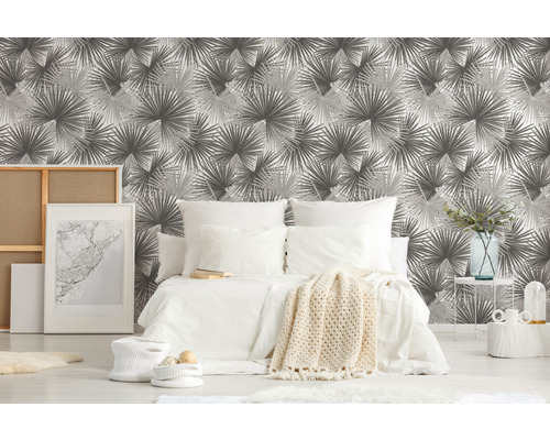 Schlafzimmer mit gemusterter Tapete, Bett und Dekorationsartikeln für ein gemütliches Ambiente.