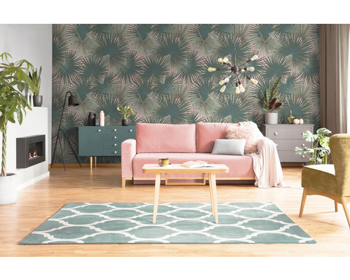 Wohnzimmer mit Tapete mit Palmenmuster, Sofa, Teppich und Möbeln.
