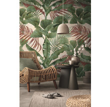 Wohnzimmer mit Rattansessel, Beistelltisch und botanischer Tapete mit Blättern