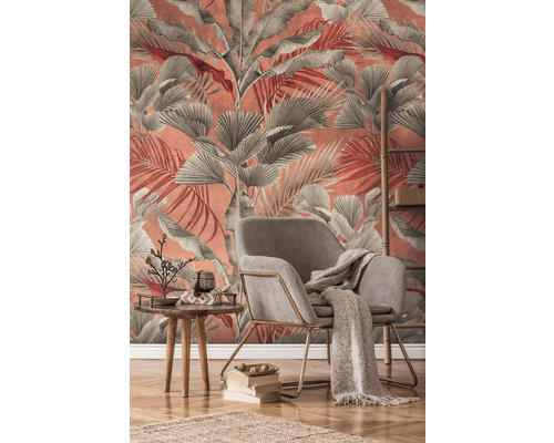 Wohnzimmer mit Sessel, Tisch und Deko vor einer Wand mit Blättertapete