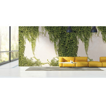 Helles Wohnzimmer mit Fensterfront, begrünter Wand und gelbem Sofa