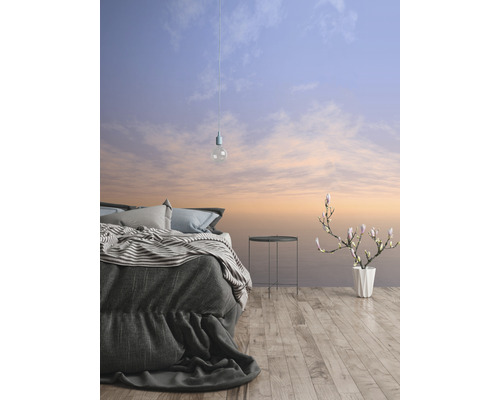 Schlafzimmer mit Bett, Beistelltisch, Blumenvase und Tapete mit Himmelsmotiv