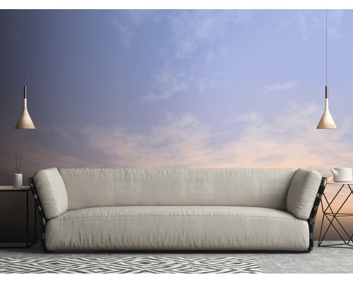 Wohnzimmer mit Sofa, Beistelltischen, Pendelleuchten und gemustertem Teppich