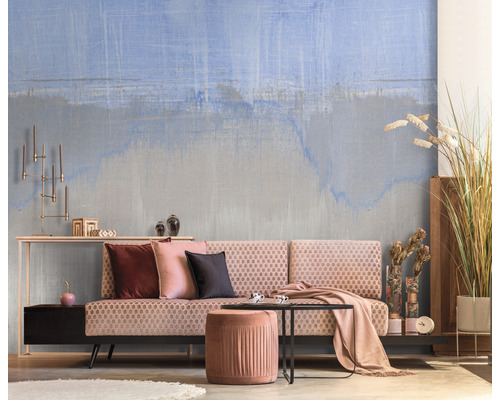 Wohnzimmer mit gemusterter Tapete, Sofa, Hocker und Dekoration