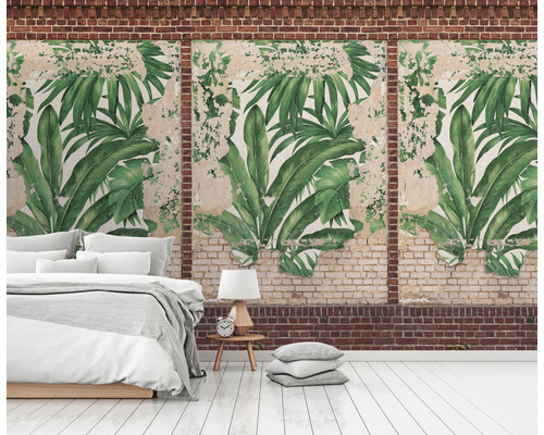 Wandgestaltung mit tropischem Blättermotiv in einem Raum mit Bett und Backsteinmauer