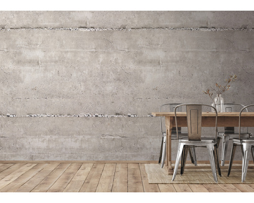 Innenraum mit Betonwand, Holztisch und Metallstühlen.