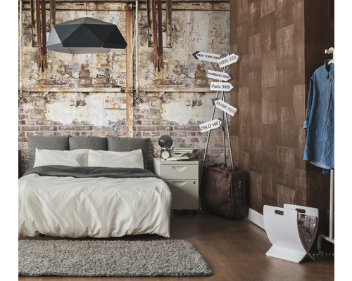 Schlafzimmer mit Bett, Nachttisch, Lampe und dekorativer Wandgestaltung im Industrial-Stil
