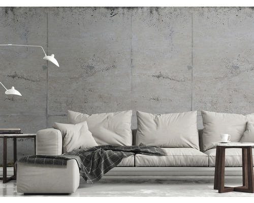 Wohnzimmer mit Sofa, Beistelltisch und Stehlampe vor einer Betonwand