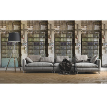 Wohnzimmer mit grauer Couch, Stehlampe und Wandtapete mit Schaltschrank-Motiv für ein industrielles Ambiente.
